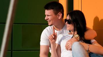 Young couple looking one way against bright wall of yellow and green photo