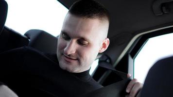 Businessman in his car fastening the seatbelt, safe driving concept photo