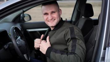 Attractive smiling young man in a car photo