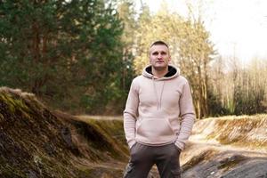 A young man in a comfortable suit walks through the forest photo