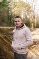 A young man in a comfortable suit walks through the forest photo