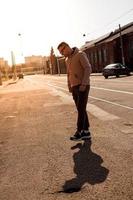 Hipster walking in the street with red brick wall building photo