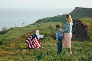 Mom and son visited the grave of the father on the memorial day photo