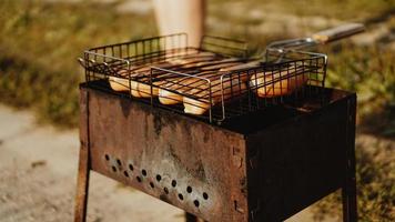 Delicious grilled sausages resting on the iron grid photo