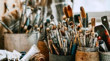 Table with brushes and tools in art workshop. Background. photo