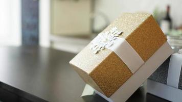 Gold present box on wood table with blurred background photo