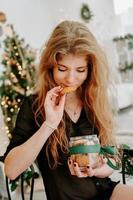 Feliz joven comiendo galletas de Navidad en la cocina