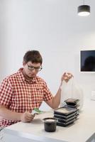 Young man sorting food delivery boxes at the modern kitchen photo