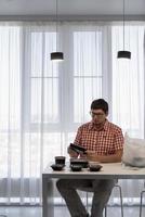 Young man sorting food delivery boxes at the modern kitchen photo