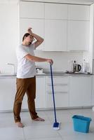 hombre limpiando casa con trapeador foto