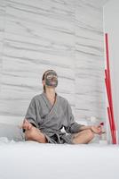 Woman with face mask relaxing sitting on the bed photo