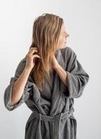 Happy young woman applying hair mask in bathroom photo