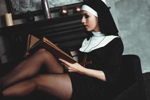 hermosa joven monja en religión traje negro tiene Biblia. religión