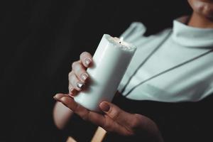 Young catholic nun is holding candle in her hands photo