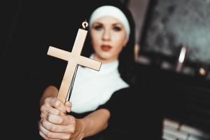 monja sosteniendo una cruz. el concepto de religión.