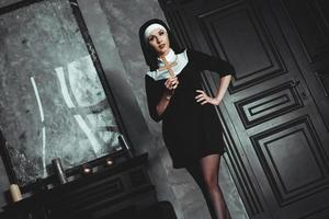 Sexy nun prays indoor. Beautiful young holy sister. photo