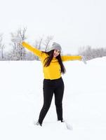 Young brunette woman playing with snow in park photo