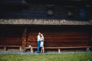 Married couple outside a wooden house photo