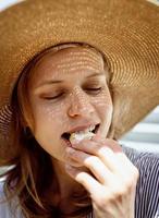 Headshot of woman eating grilled vegetables outdoors