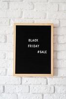 Text black friday sale on black letter board on white brick wall photo