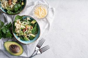 Top view of fresh summer avocado and spinach salad bowls