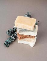 Stack of hand made soap and eucalyptus on gray background