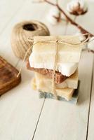 Stack of hand made soap on white wooden background photo