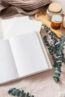 libro abierto, velas y hojas de eucalipto. maqueta de diseño foto