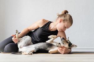 Joven deportiva abrazando a su perro de raza mixta foto