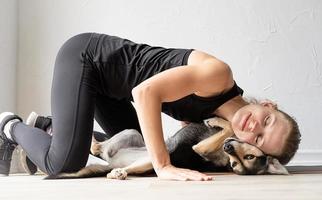 Young sportive woman embracing her mixed breed dog photo