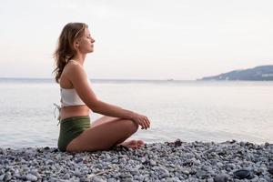 mujer joven, meditar, en la playa foto