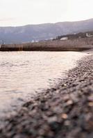 Playa de piedras de guijarros y el mar, fondo de naturaleza