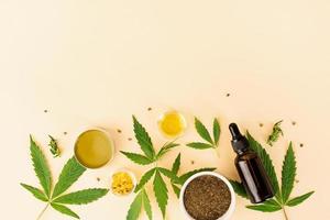 Cbd oil and cannabis leaves cosmetics top view on orange background