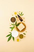 Cbd oil and cannabis leaves cosmetics front view on orange background photo