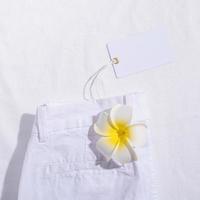 White summer jeans on white fabric background with blank price tag photo