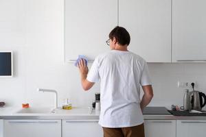 hombre limpiando las superficies de la cocina foto