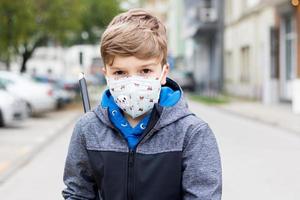 Retrato de un niño con mascarilla protectora en las calles de la ciudad. foto