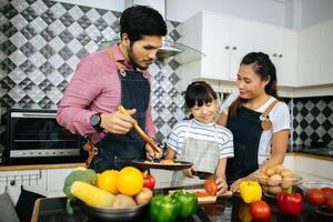 familia feliz ayuda a cocinar juntos en la cocina de casa. foto