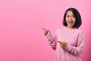 Portrait of surprised woman pointing at empty space