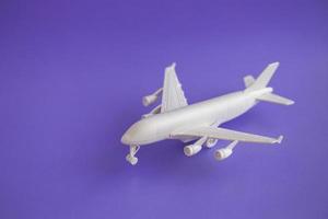 Avión de juguete de plástico sobre un fondo violeta y copie el espacio