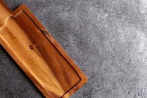 Wooden cutting board on black table background photo