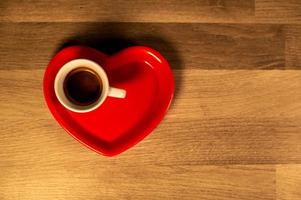 platillo de corazón de san valentín con taza de café foto