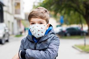 Small boy with KN95 face mask in the city. photo