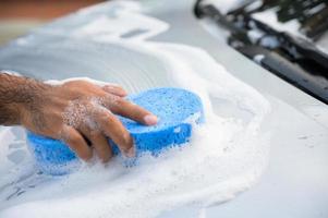 Man cleaning washing car with sponge and foam photo