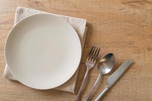 Empty plate or dish with knife, fork and spoon photo