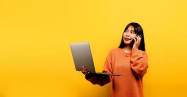 Concepto de comunicación en línea chica asiática usa portátil en casa amarillo foto