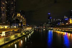 El centro de la ciudad de Melbourne al lado del río horizonte urbano moderno por la noche en Australia foto