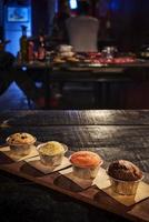 Mixed freshly baked muffins on table in cozy coffeeshop interior photo