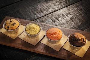 Mixed freshly baked muffins on table in cozy coffeeshop interior photo