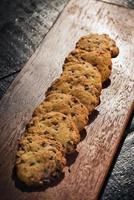 Chocolate chip cookie biscuits on rustic wooden board photo